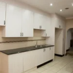 The shared kitchen with white cabinets