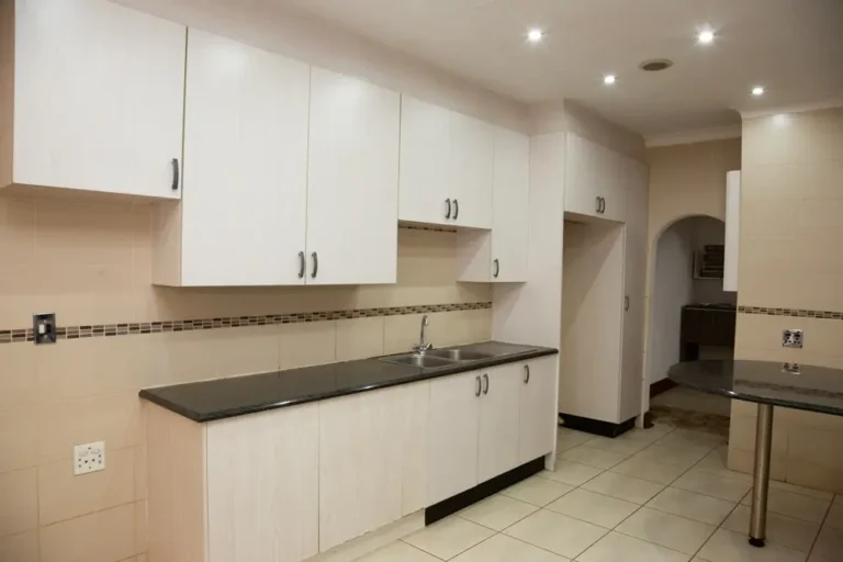 The shared kitchen with white cabinets